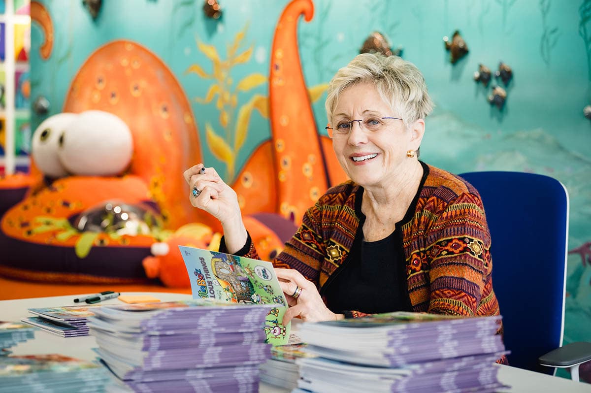 Lynn Johnston in her studio with a pile of Alottabotz&reg; books.